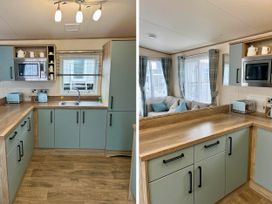 A kitchen with cabinets and appliances at Static Caravan Hoburne Devon Bay
