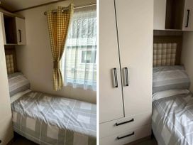 A bedroom with a bed and wardrobe at Static Caravan Hoburne Devon Bay