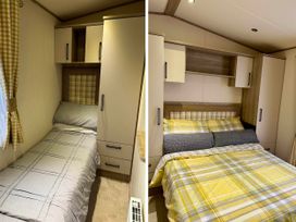 A bedroom with a bed and cabinets in Static Caravan Hoburne Devon Bay 