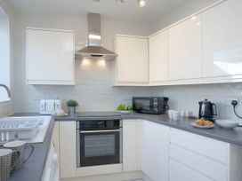 A kitchen with a stove, microwave, and countertop items at Torquay - House - Sleeps 6 - Pet Friendly