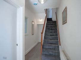 A hallway with stairs and mirrors at Torquay - House - Sleeps 6 - Pet Friendly