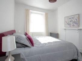 A bedroom with a bed and lamp at Torquay - House - Sleeps 6 - Pet Friendly