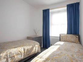 A bedroom with two beds and a nightstand at Torquay - House - Sleeps 6 - Pet Friendly