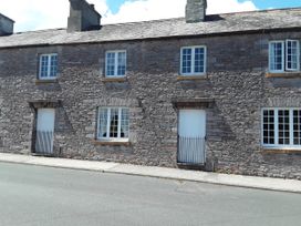 A stone building with windows and a front door at Quiet cottage on the rural edge of Brixham