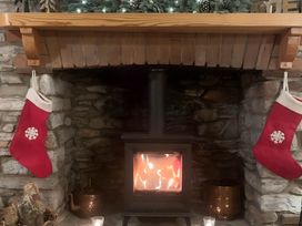 A fireplace with stockings and a wood stove at Quiet cottage on the rural edge of Brixham