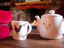 A mug and teapot on a table in a living room at Quiet cottage on the rural edge of Brixham