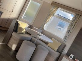 A dining area with a round table and cushions at Beverley bay 2-Bed Caravan, Sleeps 6, Pet Friendly