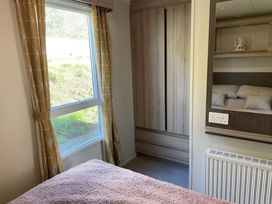 A bedroom with a window and wardrobe at Beverley bay 2-Bed Caravan, Sleeps 6, Pet Friendly