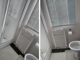 A bathroom with a shower enclosure, toilet, and radiator at Beverley bay 2-Bed Caravan, Sleeps 6, Pet Friendly