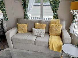 A living room with a sofa and cushions at Blue water 3 Beverley Bay Static Caravan in Paignton