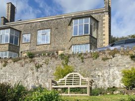 A garden with a bench and stone wall at Beachside 2-Bed - Sleeps 4, Parking & Pet Friendly, Salcombe