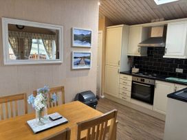 A kitchen with a table and chairs at 2 Bed Lodge-Sleeps 4-stunning views -Pet Friendly in Troutbeck