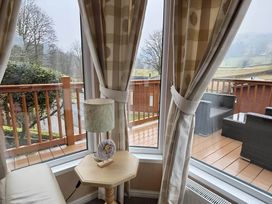 A living room with a side table and a lamp at 2 Bed Lodge-Sleeps 4-stunning views -Pet Friendly in Troutbeck