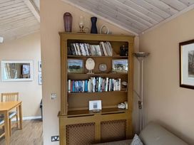 A living room with a bookshelf and dining table at 2 Bed Lodge-Sleeps 4-stunning views -Pet Friendly in Troutbeck