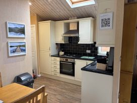A kitchen with cabinets, stove, and countertop at 2 Bed Lodge-Sleeps 4-stunning views -Pet Friendly, Troutbeck