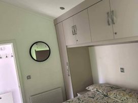 A bedroom with a bed, mirror, and cupboard at 2 Bed Lodge-Sleeps 4-stunning views -Pet Friendly in Troutbeck