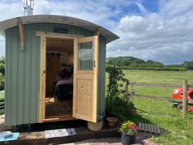 An outdoor view of a shepherd hut with an open door at Shepherd Hut in Gloucester
