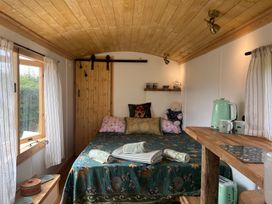 A bedroom with a bed and kettle in Shepherd Hut in Gloucester