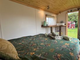 A sleeping area with a bed and a sink at Shepherd Hut in Gloucester