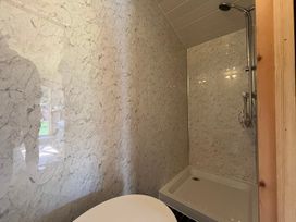 A bathroom with a shower and bathtub at Shepherd Hut in Gloucester