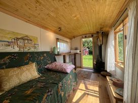 A living room with a sofa and a table at Shepherd Hut in Gloucester