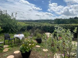 A garden with a table and chairs at Shepherd Hut Gloucester