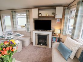 A living room with a sofa and television at Pepper Pot Lodge in Knaresborough