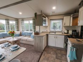 A kitchen and living area with sofa and dining table at Pepper Pot Lodge in Knaresborough