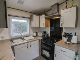 A kitchen with appliances and cabinets at Pepper Pot Lodge in Knaresborough