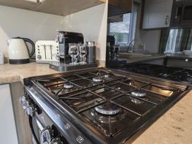 A kitchen with a gas stove and various appliances at Pepper Pot Lodge in Knaresborough