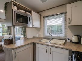 A kitchen with a microwave and sink at Pepper Pot Lodge in Knaresborough
