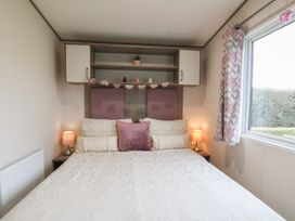 A bedroom with a bed and lamps at Pepper Pot Lodge in Knaresborough