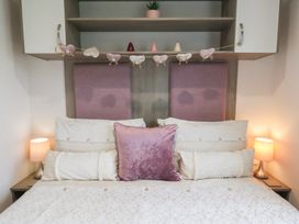 A bedroom with a bed and bedside lamps at Pepper Pot Lodge in Knaresborough