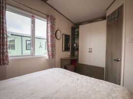 A bedroom with a bed and wardrobe at Pepper Pot Lodge in Knaresborough