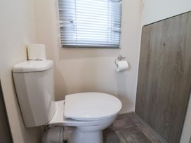 A bathroom with a toilet and window at Pepper Pot Lodge in Knaresborough