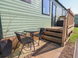 An outdoor seating area with a table and chairs at Pepper Pot Lodge in Knaresborough