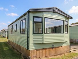 A mobile home with windows and green siding at Pepper Pot Lodge in Knaresborough