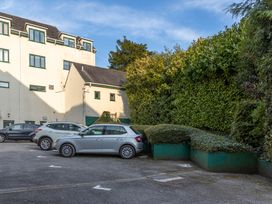 A parking lot with cars and greenery at Luxury 2 Bed Room Lake View Apt Bowness Parking Bowness-On-Windermere