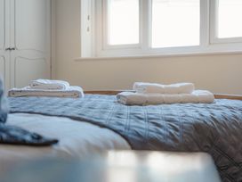 A bedroom with towels folded on the bed at Luxury 2 Bed Room Lake View Apt Bowness Parking Bowness-On-Windermere