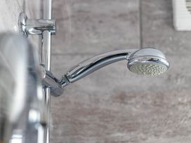 A showerhead with shower arm in a bathroom at Luxury 2 Bed Room Lake View Apt Bowness Parking Bowness-On-Windermere