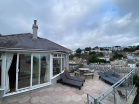 An outdoor area with deck chairs and a table at 4 Bed House-Sleeps 8-Parking-Pets-MarinaSeaView in Torquay