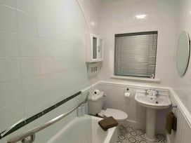 A bathroom featuring a bathtub, toilet, sink, and window at 4 Bed House-Sleeps 8-Parking-Pets-MarinaSeaView in Torquay