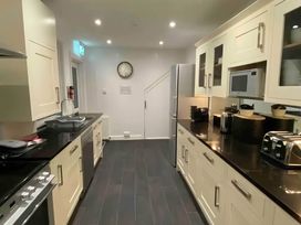A kitchen with appliances and cabinets at 4 Bed House-Sleeps 8-Parking-Pets-MarinaSeaView in Torquay