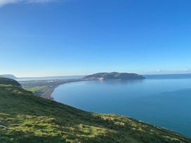 A coastline view with hills and water at Sea View, East Parade in Llandudno