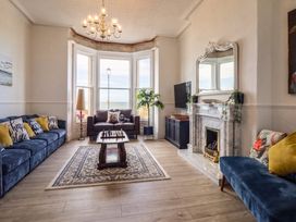 A living room with a table and sofa at Sea View, East Parade in Llandudno