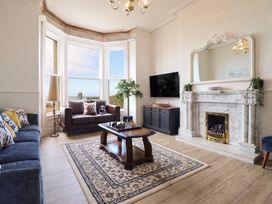 A living room with a television and seating at Sea View, East Parade Llandudno