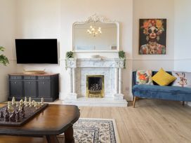 A living room with a fireplace and television at Sea View, East Parade in Llandudno