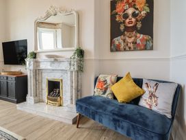 A living room with a sofa and fireplace at Sea View, East Parade, Llandudno