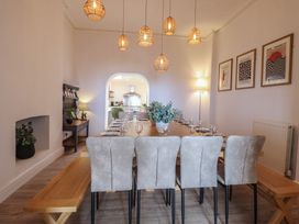 A dining room with a long table and chairs at Sea View, East Parade, Llandudno