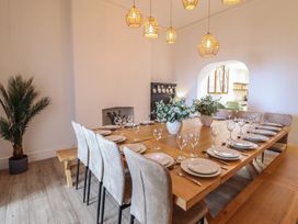 A dining room with a large table and chairs at Sea View, East Parade in Llandudno